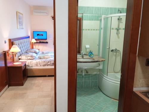 a bathroom with a bed and a sink and a shower at Nonna Marija 1 in Rovinj