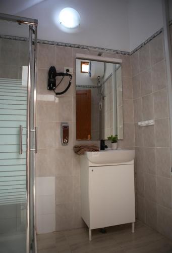 a bathroom with a sink and a shower with a mirror at Casa Pano Beach House in Ajuy