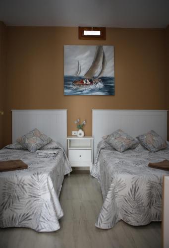 a bedroom with two beds and a painting on the wall at Casa Pano Beach House in Ajuy