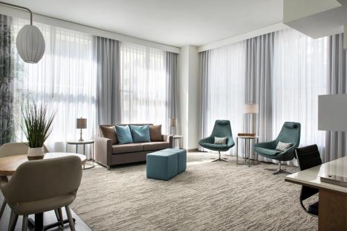a living room with a couch and chairs at EVEN Hotel Pittsburgh Downtown by IHG in Pittsburgh