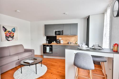 une cuisine et un salon avec un canapé et une table dans l'établissement LE COCON #Centre ville #100m de la Charente, à Cognac