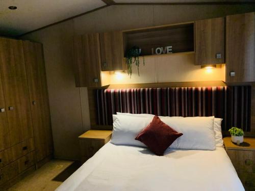 sypialnia z łóżkiem z białą pościelą i czerwonymi poduszkami w obiekcie Hoburne Devon Bay Paignton L48 w mieście Paignton