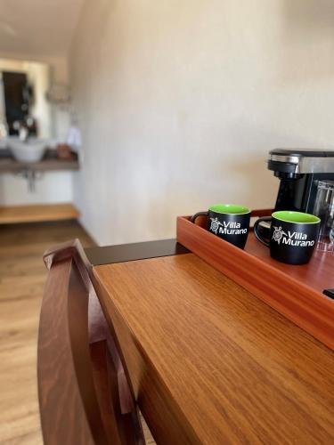 three coffee cups sitting on top of a wooden counter at Hotel Villa Murano in San Cristóbal de Las Casas