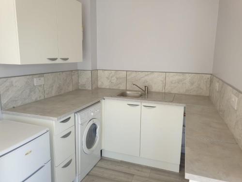 a kitchen with a washing machine and a sink at Garden Room in Northolt