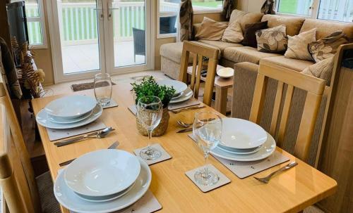 a dining room table with plates and glasses on it at Hoburne Devon Bay Paignton L48 in Paignton