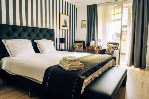 ein Schlafzimmer mit einem Bett mit einer schwarz-weißen gestreiften Wand in der Unterkunft Boutique Hotel Joli Bois in De Haan