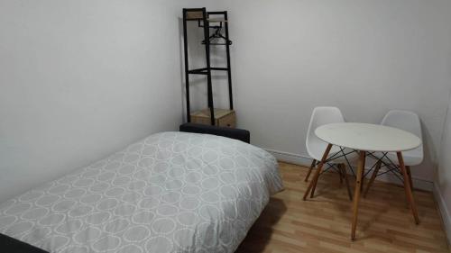 a bedroom with a bed and a table and a stool at Appartement 5 - tout équipé - Carmes, Toulouse in Toulouse