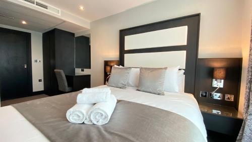 a bedroom with a large bed with towels on it at Hatton Garden Hotel in London