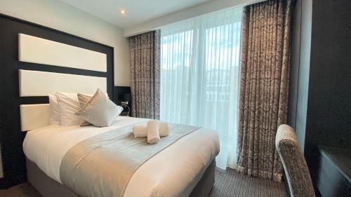 a bedroom with a bed and a large window at Hatton Garden Hotel in London
