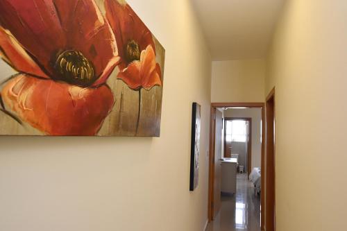 a painting of a flower hanging on a wall at 101 Moroni by Cast Renting in Il-Gżira