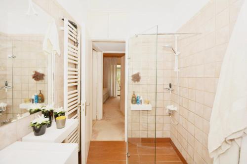 a bathroom with a shower and a glass door at Villasonboard Vouliagmeni Condo Lux & Comfy Riviera & beach in Athens