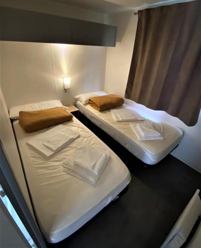 two twin beds in a room with a window at Camping Igara de San Sebastian in Donostia-San Sebastián