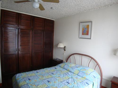 a bedroom with a bed and a ceiling fan at Hotel La Guaria Inn & Suites in Alajuela City
