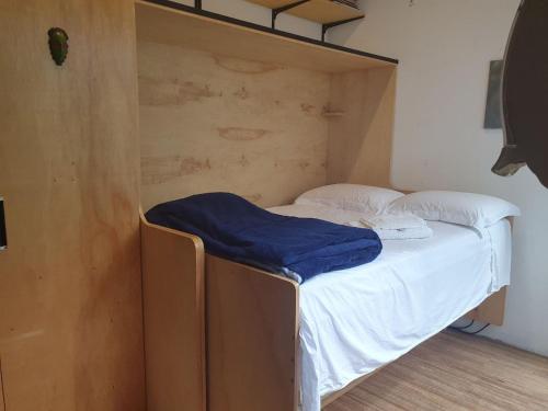 a bed with a blue blanket on it in a room at Hospedagem Casa Paulista in São Paulo