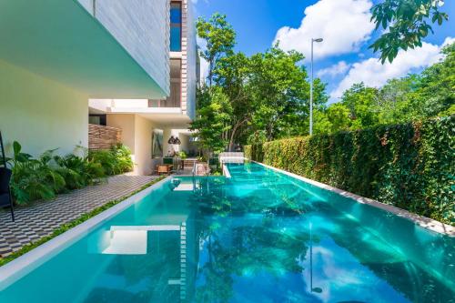a swimming pool in the backyard of a house at Casa Libre - Awesome designer 3Br in Aldea Zama by StayPodio 306 in Tulum