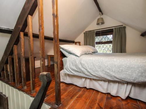 Schlafzimmer mit einem Bett und Holzboden in der Unterkunft Coachman's in Forrabury