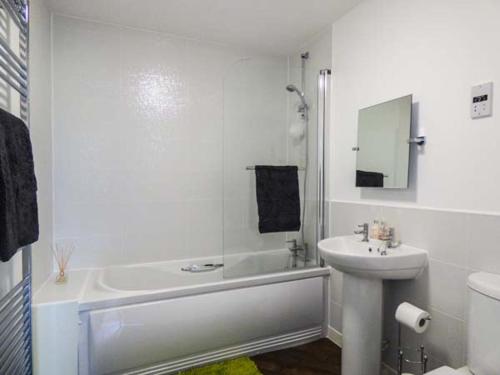a white bathroom with a sink and a tub and a toilet at Tehidy in Charlestown