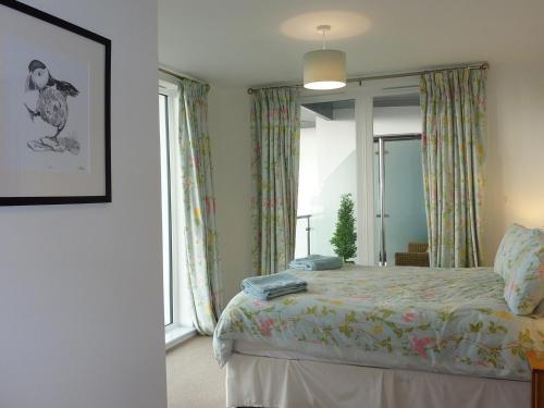 Un dormitorio con una cama y una ventana grande. en 28 Clock Tower Court, en Charlestown