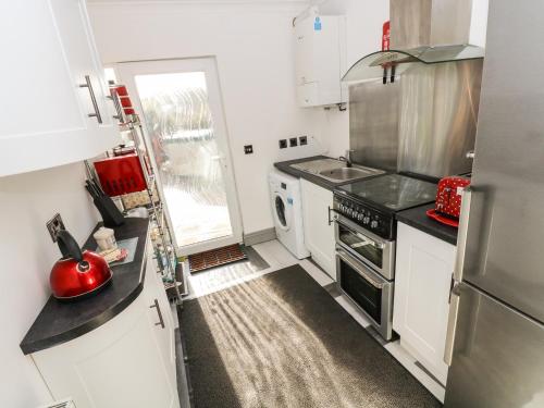 a small kitchen with a stove and a sink at Chapel Green Studio in St Austell