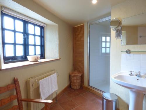 a bathroom with a sink and a shower at Meadow Cottage in Fowey