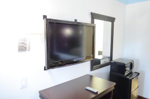 uma grande televisão de ecrã plano pendurada numa parede em Sterling Inn and Suites at Reliant and Medical Center Houston em Houston