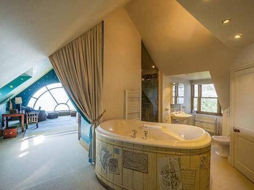 uma grande casa de banho com uma grande banheira num quarto em Cragford em Trevilley