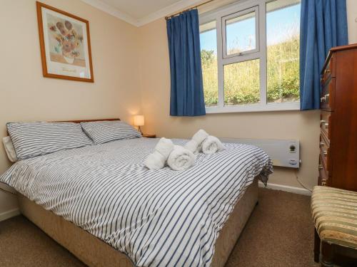 ein Schlafzimmer mit einem Bett mit Handtüchern darauf in der Unterkunft The Shack in Mawgan Porth