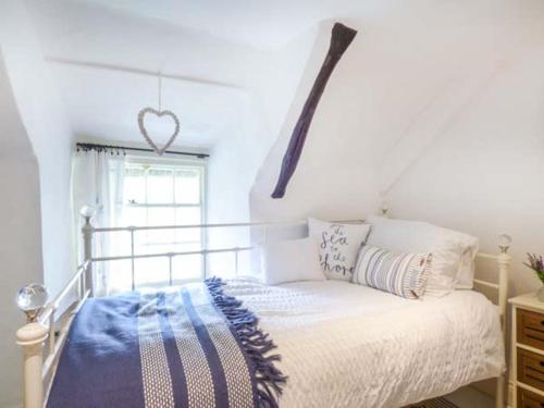a bedroom with a bed with a heart sign on the wall at Bee Hive Cottage in Morwenstow