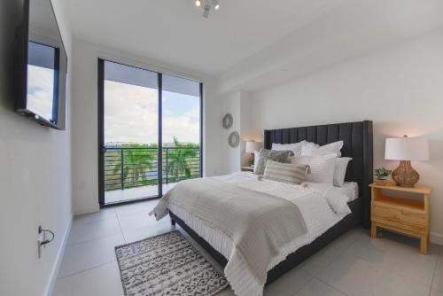 um quarto com uma cama grande e uma janela grande em Cozy 1-1 BR Steps from Downtown Doral Park em Miami