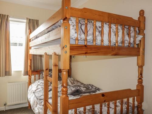 ein hölzernes Etagenbett in einem Schlafzimmer in der Unterkunft 11 Pendarves in Saint Merryn