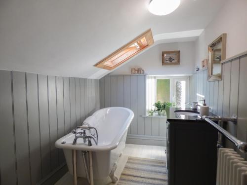 a bathroom with a white tub and a sink at Pretoria in Coverack