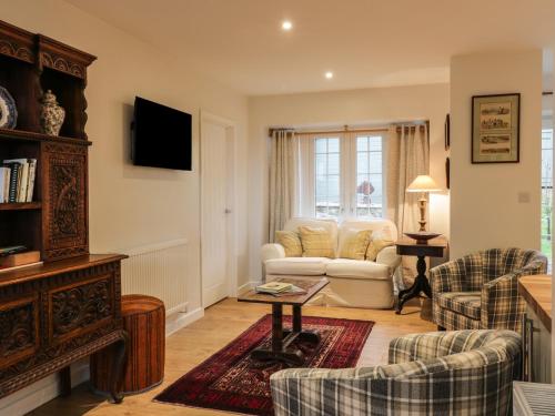 a living room with a couch and a table at The Coach House in Bodmin