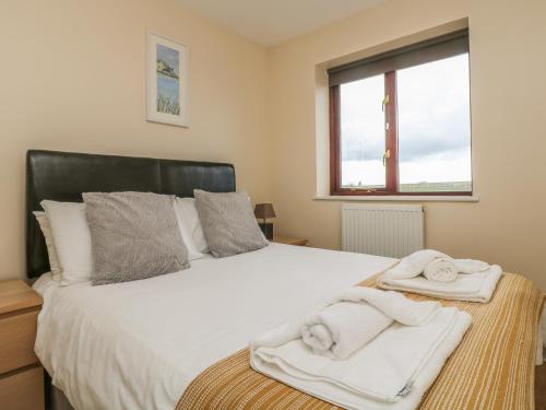 a bedroom with a bed with towels on it at Shoreline in Marazion