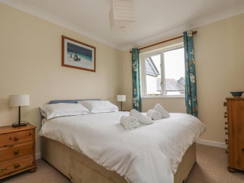 a bedroom with a large bed with towels on it at Cuckoo's Cottage in Falmouth