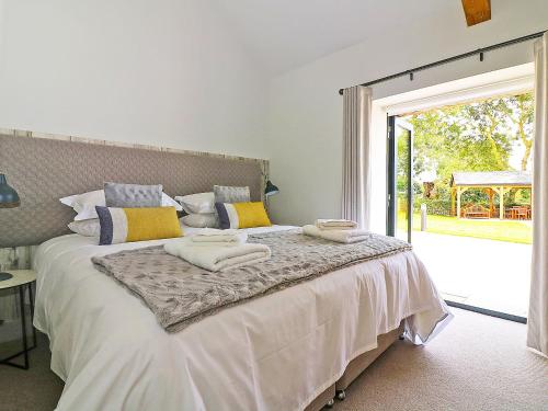 Un dormitorio con una cama con toallas. en The Stable, Boskensoe Barns, en Falmouth
