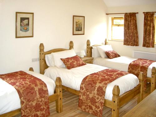 Abbey-CwmhirにあるHappy Union Stablesのベッドルーム1室(ベッド3台付)