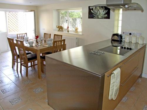 a kitchen and dining room with a counter and a table at Rosewaters Cottage in Shrawley