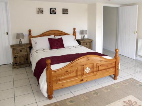 a bedroom with a large wooden bed and two night stands at Rosewaters Cottage in Shrawley