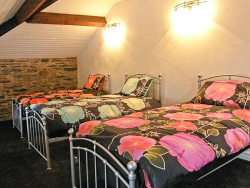 dos camas sentadas una al lado de la otra en una habitación en Hendre Aled Farmhouse en Llansannan