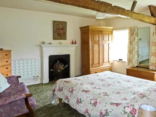 a bedroom with a large bed and a fireplace at High Sprintgill Cottage in Ravenstonedale