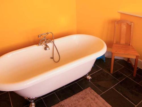 a white bath tub in a bathroom with a table at The Methodist Chapel in Whiteparish