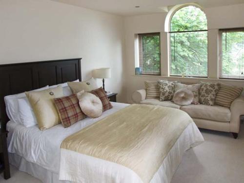 a bedroom with a large bed and a couch at Clouds Hill in Almondbury