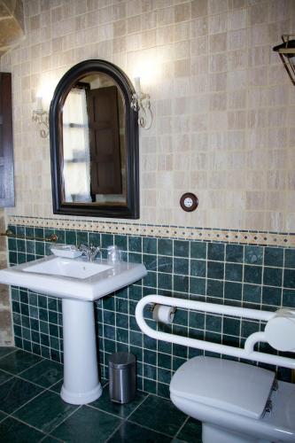 a bathroom with a sink and a toilet and a mirror at CASA RURAL LARRAZURIA ENEA in Labastida
