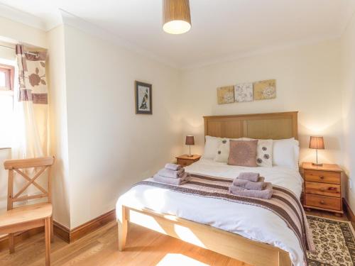 1 dormitorio con 1 cama grande y 2 mesitas de noche en Ridge Cottage, en Longwitton