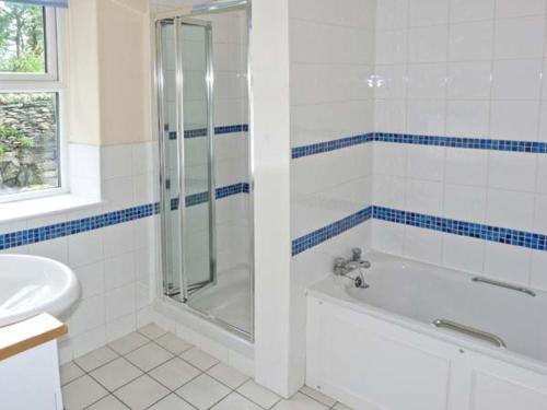 a bathroom with a shower and a tub and a sink at Rothay Cottage in Ambleside