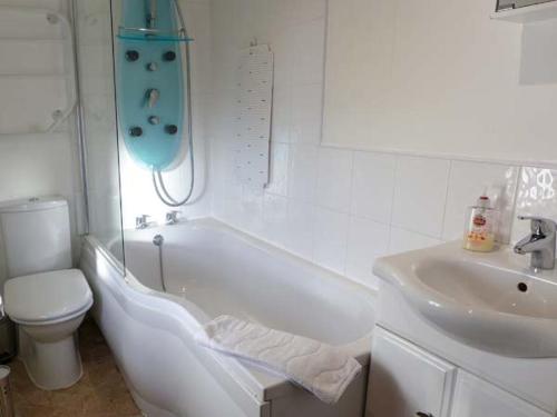 a bathroom with a tub and a toilet and a sink at 1 Primitive Mews in Chelmorton