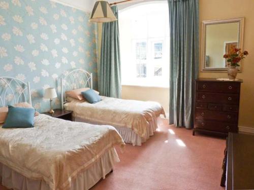 a bedroom with two beds and a mirror at Smardale Hall in Crosby Garrett