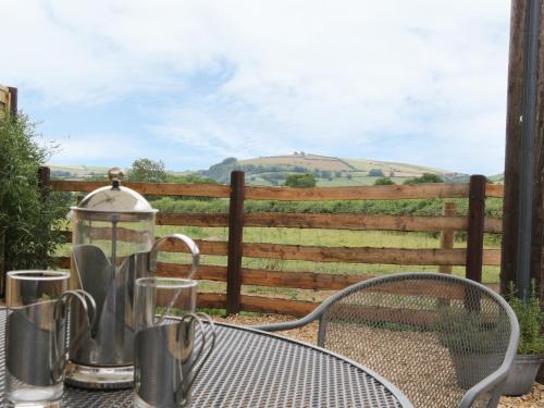 a table and chairs in front of a fence at Bicton Lodge in Clun