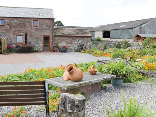 a pot sitting on a bench in a garden at Piggery Cottage in Wigton