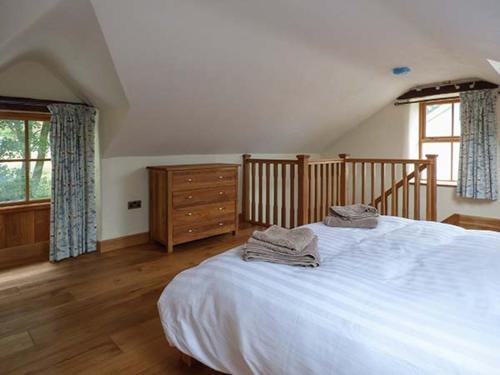 a bedroom with a large white bed and a dresser at Briws in Llangwm